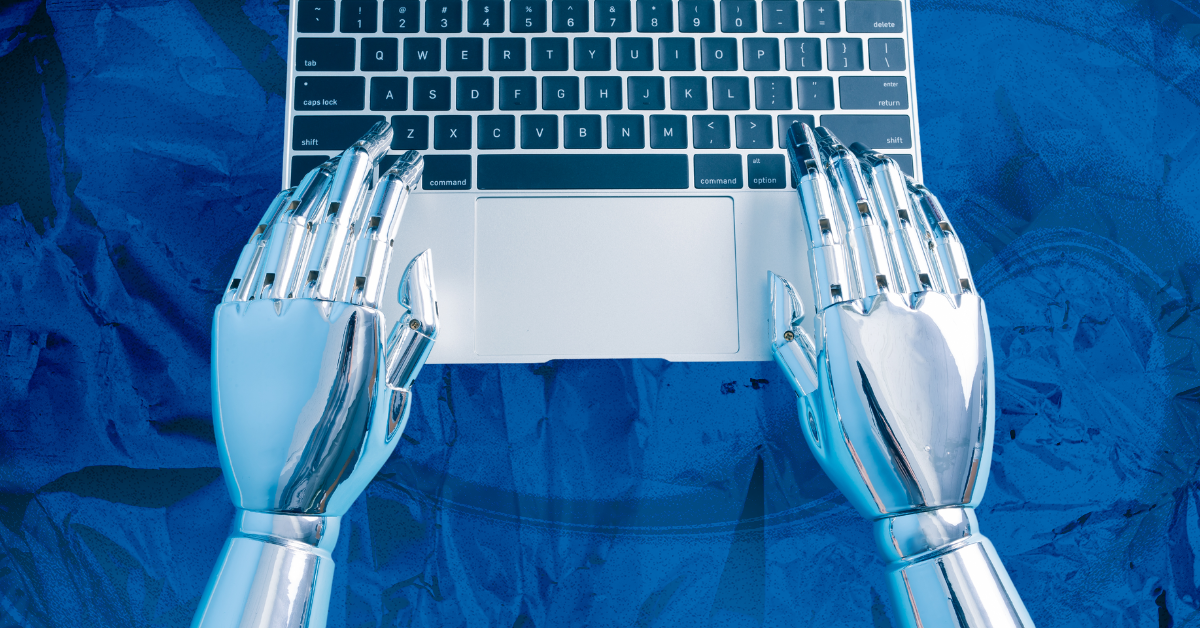 Robot hands hover above a laptop’s keyboard.