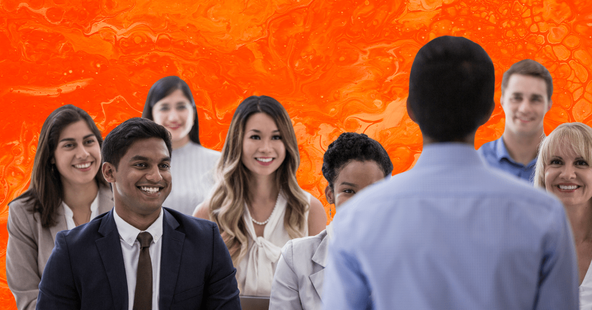 A group of people in business attire smiling and looking at a man in a dress shirt.