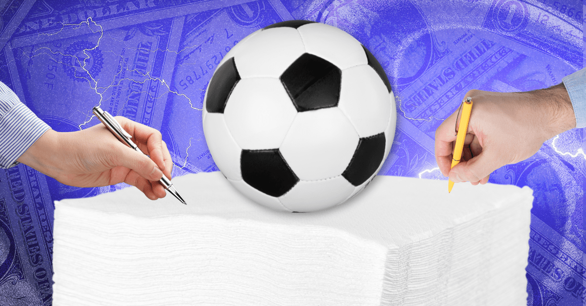 Two hands holding pens hover atop a pile of white paper napkins with a soccer ball sitting on it.