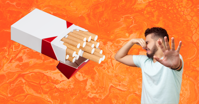 A man holds his nose in disgust next to a giant pack of cigarettes on an orange background.